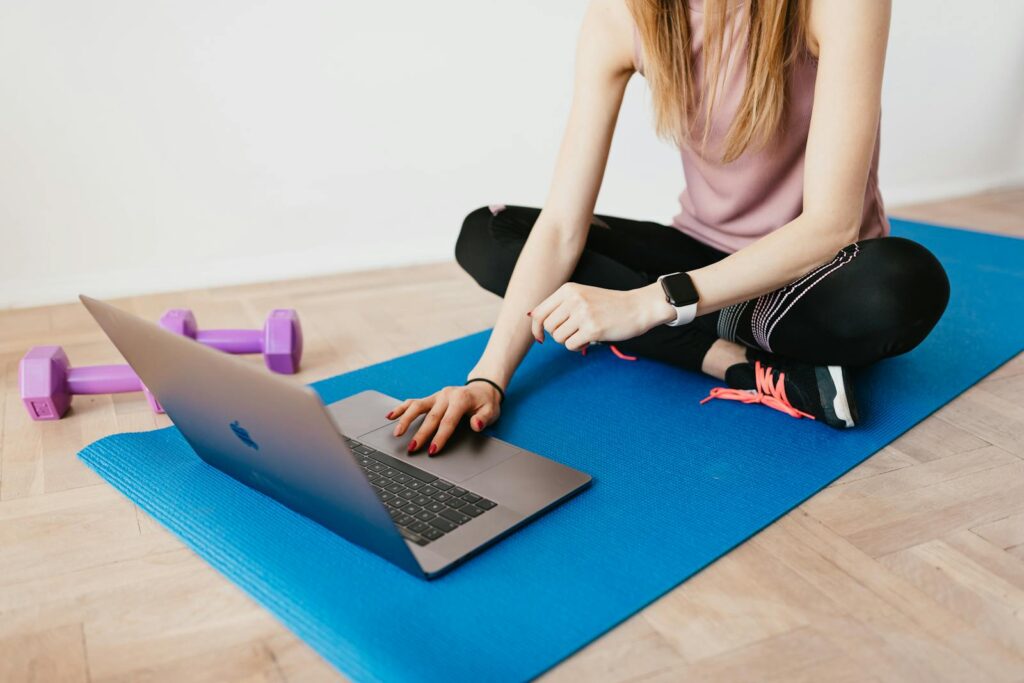 Treino remoto em casa com laptop transmitindo orientação do coach