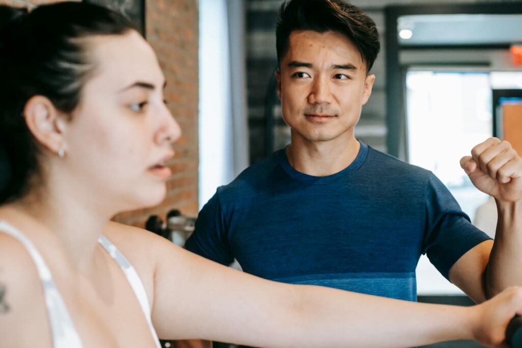 Personal trainer de uniforme profissional em ambiente de academia
