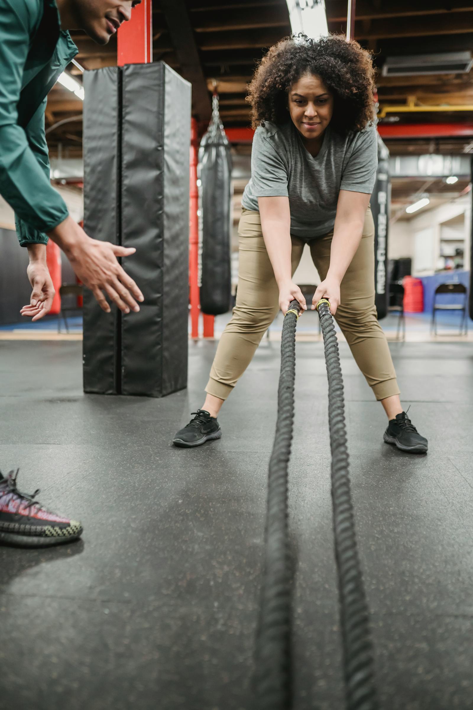 Personal trainer orientando aluno em exercício de força