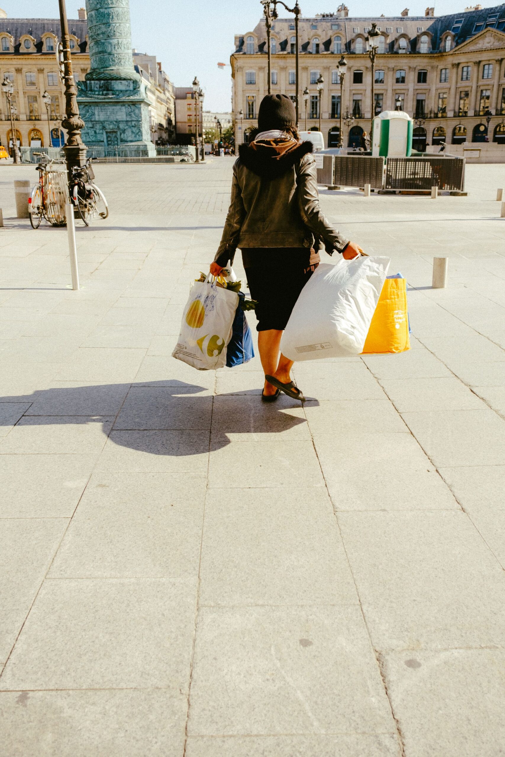 Pessoa carregando sacolas de compras pesadas na rua, exemplo de massa magra como função no dia a dia
